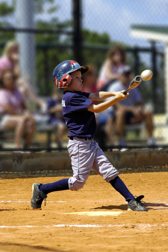 Kid playing baseball hitting with a bat Kid playing baseball hitting with a bat