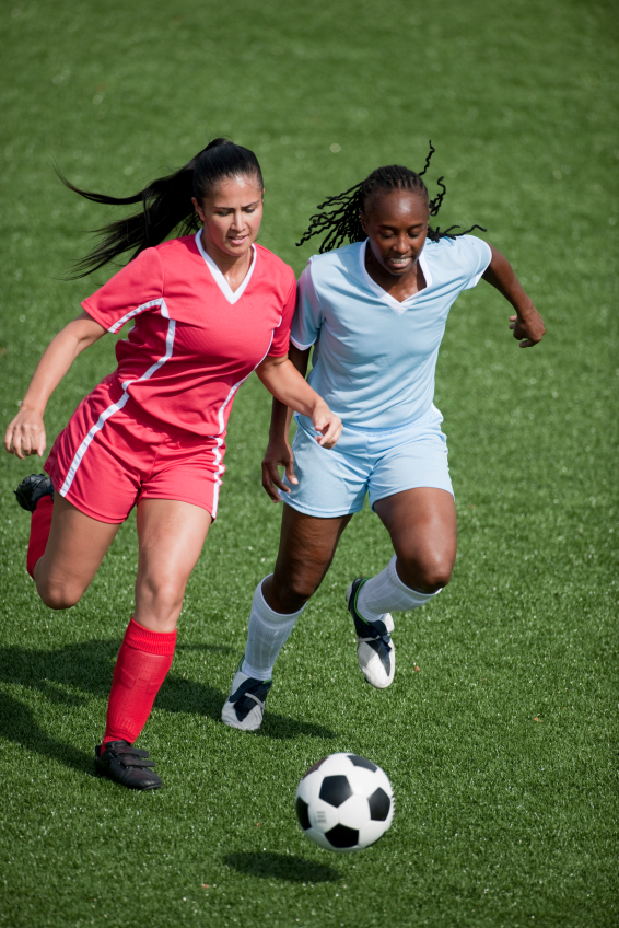 Two female soccer players competing for the ball, aerial view. Two female soccer players competing for the ball, aerial view.